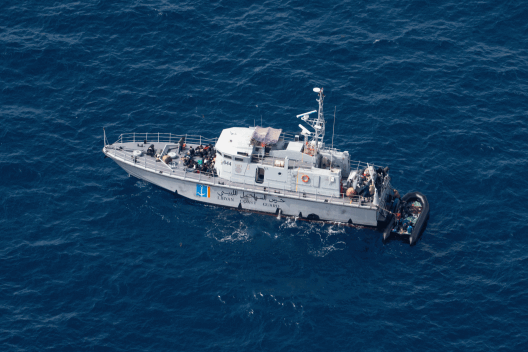 A vessel of the Libyan Coast Guard taking people from overcrowded boat in distress at sea during an